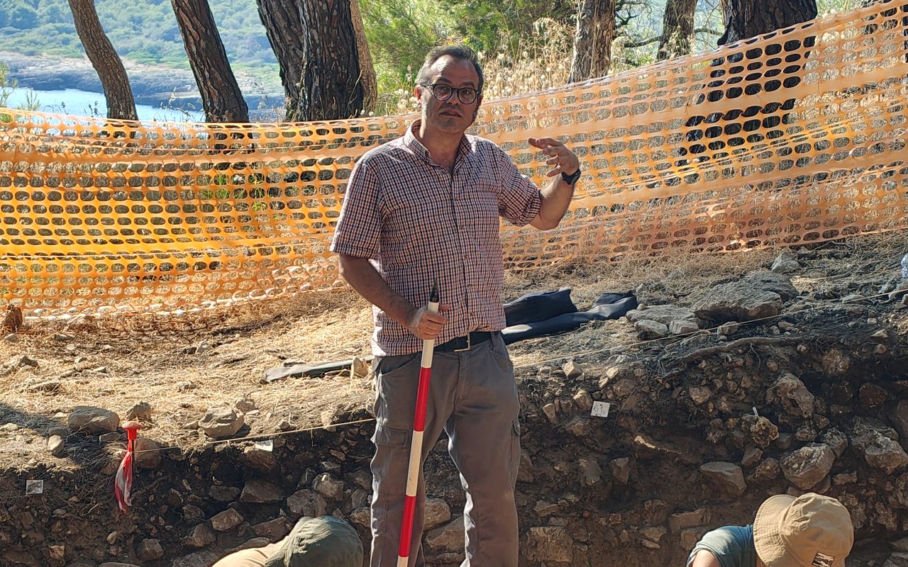 The excavation at Torre dell'Alto: the director explaining the trench while two excavators work by the buckets